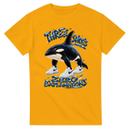 Gold t-shirt printed with Orcalero Orcala and the words Three shoes, zero explanations, front view