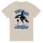 Sand t-shirt printed with Orcalero Orcala and the words Three shoes, zero explanations, front view